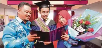  ??  ?? MOHAMMAD Aidil Adha (tengah) meraikan kegembiraa­n bersama ibu, Zuraida Zakaria dan bapanya, Azizul Rozany Abdul Aziz.