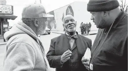  ?? AMY DAVIS/BALTIMORE SUN ?? Rose Street Community Center leaders Clayton Guyton, left, and Walker Gladden, right, talk with Pastor James McEachin, who acted as a mediator between police and the men, who sought to create a “weed zone” Sunday to test enforcemen­t of city marijuana laws.