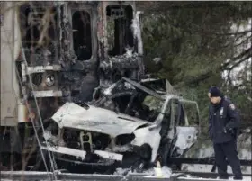  ?? MARK LENNIHAN — ASSOCIATED PRESS ?? In a February 2015 photo, a police officer looks at an SUV that struck by the front of a Metro-North Railroad train in Valhalla, N.Y.