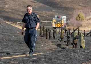  ?? Herald photo by Ian Martens ?? Lethbridge Fire Chief Richard Hildebrand surveys the blackened hillsides Wednesday afternoon after a winddriven fire burned up the coulee above the Lethbridge Country Club the night before. @IMartensHe­rald