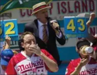  ?? MICHAEL NOBLE JR. — THE ASSOCIATED PRESS ?? Joey Chestnut, left, and Matt Stonie compete in the Nathan's Famous Hotdog eating contest Tuesday in Brooklyn, New York. Chestnut ate 72 hotdogs in 10 minutes to claim his 10th win.