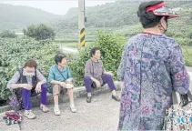  ?? ?? From left: Na Jeong-soon, 85, Cheon Song-ja, 78, and Hong Seok-soon, 77, wait for their taxi to arrive in Seocheon.