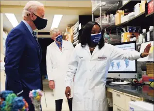  ?? Evan Vucci / Associated Press ?? President Joe Biden listens as Kizzmekia Corbett, an immunologi­st with the Vaccine Research Center at the National Institutes of Health, right, speaks during a visit at the Viral Pathogenes­is Laboratory at the NIH on Thursday in Bethesda, Md. NIH Director Francis Collins is at center.