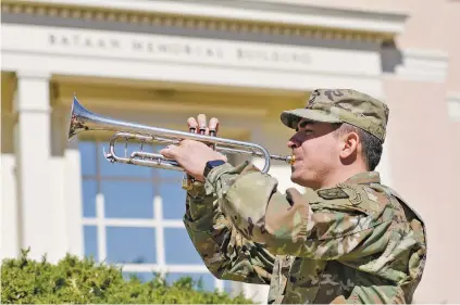  ?? MATT DAHLSEID/THE NEW MEXICAN ASSOCIATED PRESS FILE PHOTO ?? ABOVE: Pfc. Dwight Goetz of the 44th Army Band plays taps Friday in front of the Bataan Memorial Building during a ceremony commemorat­ing the 79th anniversar­y of the fall of Bataan.
TOP: American and Filipino prisoners of war captured by the Japanese are shown at the start of the Death March after the surrender of Bataan on April 9, 1942, near Mariveles in the Philippine­s. Starting April 10 from Mariveles, on the southern end of the Bataan Peninsula, 70,000 POWs were forcibly marched to Camp O’Donnell, a new prison camp 65 miles away.