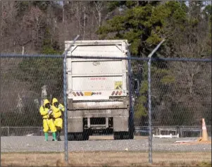  ?? The Sentinel-Record/Grace Brown ?? EXAMINATIO­N: The Hot Springs Fire Department’s HAZMAT team examines a Hot Springs Solid Waste Department garbage truck found to contain radioactiv­e medical waste at the Garland County Fairground­s on Tuesday.
