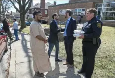  ?? Steve Mellon/Post-Gazette ?? From left, Mohammed Rahman and Muhammed Haq thank Dan Gilman, chief of staff to Mayor Bill Peduto, and Pittsburgh Police Commander Kathy Degler shortly before Friday prayers at the Islamic Center of Pittsburgh.
