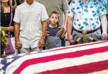  ?? AP PHOTO BY J. SCOTT APPLEWHITE ?? Members of the public walk past the flag-draped casket bearing the remains of John McCain of Arizona, who lived and worked in Congress over four decades, in the U.S. Capitol rotunda Friday.