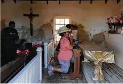  ??  ?? Marina Vásquez (centro) e Ileana García-Spitz rezan frente al altar en la capilla de La Lomita el sábado 12 de octubre en el Valle del Río Grande, Texas.