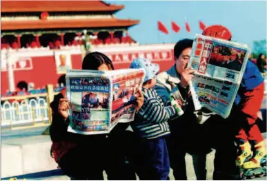  ??  ?? People read the news about China's accession to the World Trade Organizati­on ( WTO) at Tian'anmen Square, Beijing, in 2001. Since China joined the WTO, it has been actively fulfilling its WTO commitment­s and making greater contributi­ons to the world economy. CFB