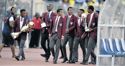  ?? / FRENNIE SHIVAMBU / GALLO IMAGES ?? Clapham High School players, who defended the Copa Coca-Cola trophy last month, parade the silverware during the match between Sundowns and Wits recently.