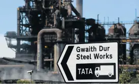  ?? /Reuters ?? Liability: A road sign points to the Tata steel works in Port Talbot, Wales, the least profitable factory of the joint venture. Tata Steel will remain liable for environmen­tal risks in Britain.