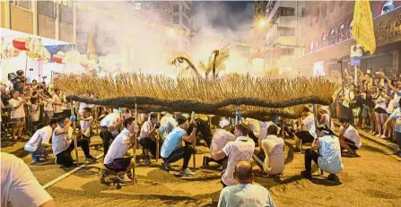  ??  ?? Fire dragon dancers performing in the streets of Tai Hang. — AP Upholding tradition: