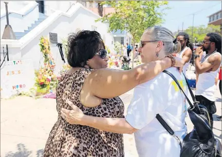  ?? Curtis Compton
Atlanta Journal-Constituti­on ?? ELAINE DAVIS, left, and Kimmie Tomlinson embrace at the sidewalk memorial outside Emanuel AME Church in Charleston, S.C., on Friday. For more than 200 years, the church has been an emblem of African Americans’ journey from slavery to freedom.
