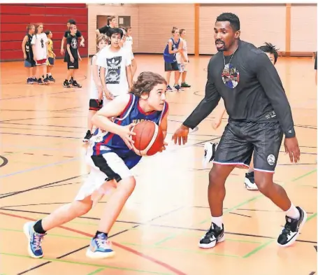  ?? FOTO: RALPH-DEREK SCHRÖDER ?? Eins zu eins gegen das Idol: Henry aus der U14-Mannschaft der ART Giants Düsseldorf nimmt es im Basketball-Training mit Flip White von den Harlem Globetrott­ers auf.