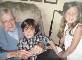  ?? John Wooden family photo ?? KNOWN SIMPLY as “Papa” to his large family, Wooden cherished moments like this, spending time with great-grandson Josh and great-granddaugh­ter Avery.