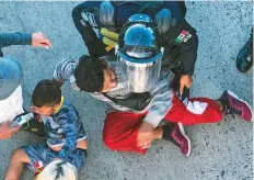  ?? AFP ?? Central American migrants are stopped by Mexican police forces as they reach the El Chaparral border crossing, in Tijuana.