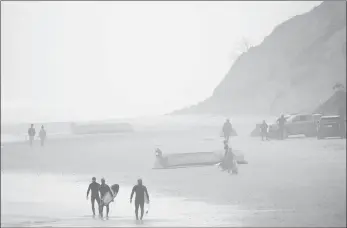  ?? GREGORY BULL/AP PHOTO ?? Two boats, one overturned, sit on Blacks Beach in San Diego on Sunday.. Authoritie­s say at least eight people were killed when two suspected migrant smuggling boats overturned off the coast of San Diego. Crews were searching for other victims.