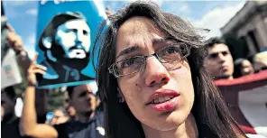  ??  ?? Left, among students gathered at Havana University to remember Castro, some were in tears; right, in Little Havana in Miami, residents celebrated his death with a giant Cuban flag