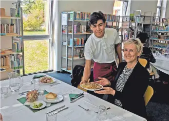  ?? FOTO: STADTVERWA­LTUNG ?? Praktikant Alireza Mohammadi serviert Gerlinde Buemann die Hauptspeis­e.