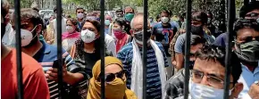  ?? AP ?? People waiting to be vaccinated against Covid-19 this week stand outside the closed gates of a hospital in Ghaziabad, on the outskirts of New Delhi in India.