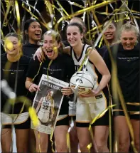  ?? ?? Iowa guard Caitlin Clark (22) stands with teammate after being presented with a commemorat­ive basketball after the team’s NCAA college basketball game against Michigan, Thursday, in Iowa City, Iowa.