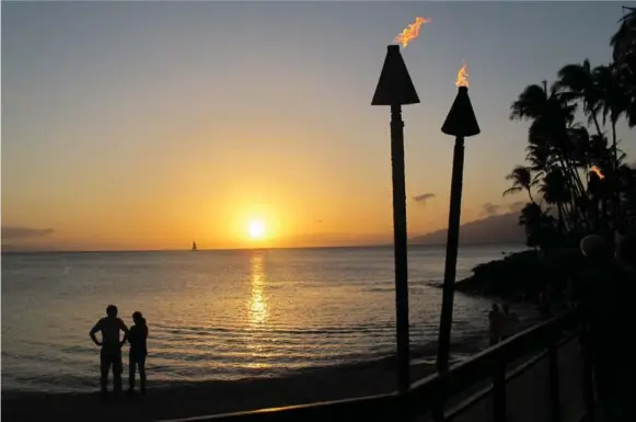  ?? JIM BYERS/TORONTO STAR ?? Tiki torches are lit at sunset at the Napili Kai Beach Resort in Maui. The beach offers superb swimming and snorkellin­g, plus sunset views of the nearby islands of Molokai and Lanai.