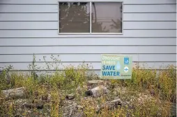  ??  ?? Top: Utility system operator Shiloh Jones writes a notice for a residence not adhering to water restrictio­ns in Santa Rosa. Above: A sign warns about drought conditions outside of a Santa Rosa residence.