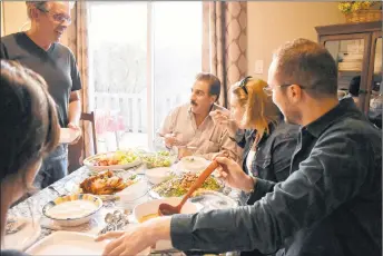  ?? FRAM DINSHAW/THE NEWS ?? Bader Albarazi and his family and sponsors enjoy a welcome dinner back at their new home in Pictou.