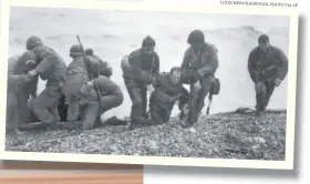  ??  ?? In this June 6, 1944, file photo, members of an American landing unit help their comrades ashore during the Normandy invasion.