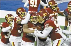  ?? AP photo ?? Washington’s Montez Sweat (center) is congratula­ted by Jeremy Reaves (39), Tim Settle (97) and others after returning an intercepti­on for a touchdown Thursday.