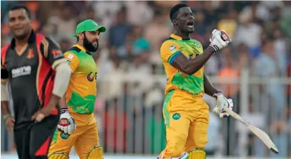  ?? — Photo by M. Sajjad ?? Andre Fletcher (right) and Shafiqulla­h of Pakhtoons celebrate their win over Rajputs at Sharjah Cricket Stadium.