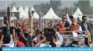  ?? — AFP ?? VARANASI: India’s Prime Minister Narendra Modi (2R) and Yogi Adityanath (3R), Chief Minister of Uttar Pradesh, greet the supporters as they arrive to inaugurate the Amul Banas Dairy plant, on the outskirts of Varanasi.