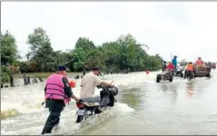  ?? POLICE ?? People travelling on a flooded road in Banteay Meanchey province on September 22.