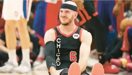  ?? JOHN J. KIM/CHICAGO TRIBUNE ?? Bulls guard Alex Caruso grimaces while holding his right knee in the fourth quarter against the Pistons on Feb. 27, at the United Center.