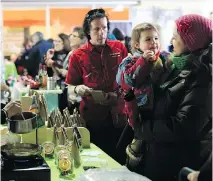  ?? NATA S H A F I L L I O N / MO N T R E A L G A Z E T T E F I L E S ?? Raphaïlle and her mother, Nathalie Bastien, try samples at the Montréal en lumière festival in 2013. The public is invited to try a variety of products at the market this weekend.
