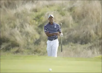  ?? The Associated Press ?? Tiger Woods of the United States watches his ball roll towards the 14th hole during a fourball match on the opening day of the 42nd Ryder Cup at Le Golf National in Saint-Quentin-en-Yvelines, outside Paris, France, on Friday.