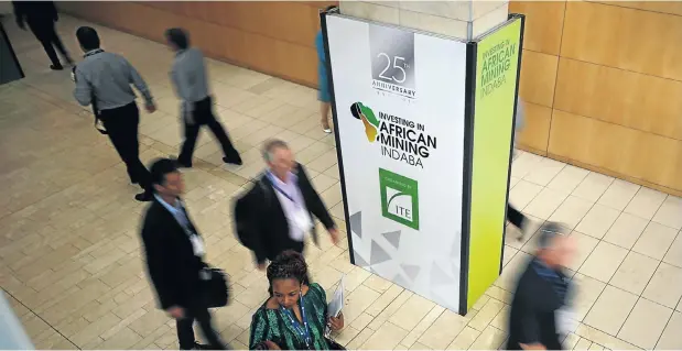  ?? Picture: Mike Hutchings/Reuters ?? Delegates walk past billboards at the Investing in African Mining Indaba conference in Cape Town on Monday.