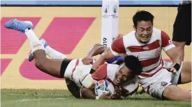  ?? REBECCA NADEN Reuters ?? JAPAN’S South African-born Kotaro Matsushima scores his team’s fourth try in their Rugby World Cup 2019 Pool A game against Samoa in the City of Toyota Stadium in Toyota.
|