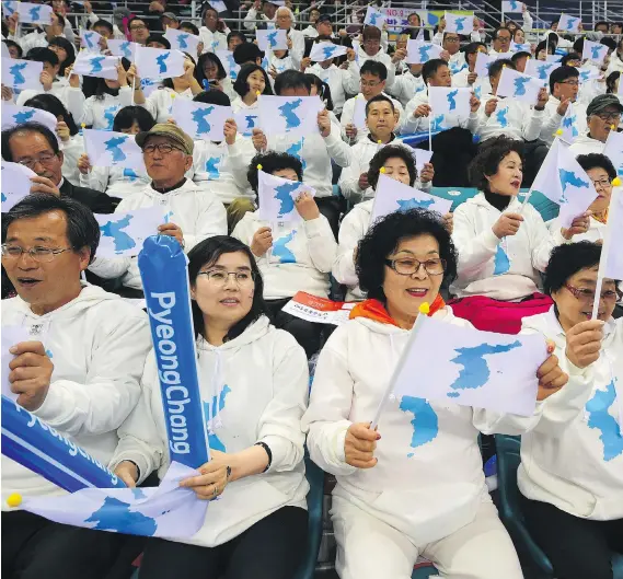  ?? PHOTOS: JUNG YEON-JE/AFP/GETTY IMAGES ?? South Korean fans wave “unificatio­n flags” during women’s world hockey championsh­ip Division II action between South Korea and North Korea in Gangneung in April. South Korea came out with the victory in a rare hockey match against the North, but the...