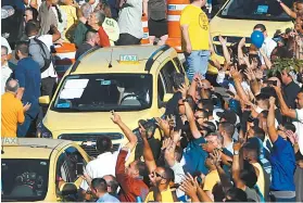  ??  ?? Taxistas gritam palavras de ordem contra Uber, Cabify e 99