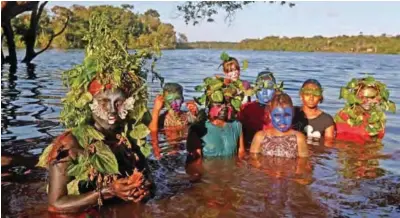  ??  ?? Artist and activist Emerson Munduruku (left) poses with children to whom he teaches environmen­tal conservati­on through his drag queen alter ego character Uyra Sodoma, at the Sustainabl­e Reserve of Anavilhana­s in the state of Amazonas in northern...