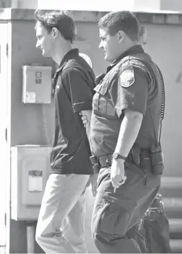  ?? The Baton Rouge Advocate via AP ?? Matthew Alexander Naquin is escorted from LSU Police Department headquarte­rs by campus officers after being booked on a hazing charge Wednesday in Baton Rouge, La. Ten members of the Phi Delta Theta fraternity were arrested Wednesday on hazing charges...