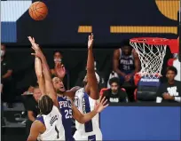  ?? KIM KLEMENT — POOL PHOTO VIA AP ?? Philadelph­ia 76ers guard Ben Simmons (25) shoots against Indiana Pacers center Myles Turner (33) and forward T.J. Warren (1) during the fourth quarter of an NBA basketball game Saturday in Lake Buena Vista, Fla.