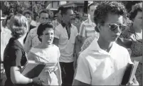  ?? File photo, Will Counts/Arkansas Democrat ?? in Little Rock shout insults at Elizabeth Eckford walking past a line of National Guardsmen, not shown, who blocked the main entrance of the school on Sept. 4, 1957.