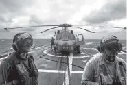  ??  ?? Sailors stand on the deck of the USS Chancellor­sville, a guided missile cruiser stationed in the South China Sea, on March 24. President Donald Trump promises to increase spending on the armed forces.