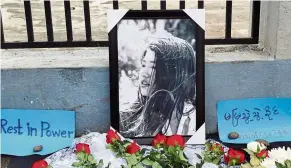  ?? — Reuters ?? Not forgotten: Flowers and signs are placed to a portrait of Mya at a memorial in Yangon.