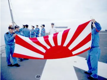  ??  ?? Sailors fold the Japanese naval ensign after a flag lowering ceremony on the deck of Japanese helicopter carrier Kaga anchored near Jakarta Port ahead of its departure for naval drills in the Indian Ocean. — Reuters photo