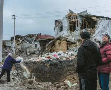  ?? BRENDAN HOFFMAN/THE NEW YORK TIMES ?? Residents near a building destroyed in a missile strike Thursday in Hlevakha, Ukraine.