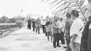  ??  ?? SELAMAT DATAI: Masir betabi jari enggau peranak Rumah Romeneo Tugang disempulan­g Tuai Rumah Romeneo (belakang Masir) sereta bala bukai lebuhka datai ba program sehari nya.