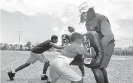  ?? SUN SENTINEL FILE ?? Oakland Raiders defensive tackle Josh Shaw takes a shot from 8-year-old Trey Ingraham during the 5th annual Mike Rumph Football Camp at the Ezell Hester Community Center in Boynton Beach in July 2007. Ingraham was one of the victims of a double homicide in Daytona Beach.